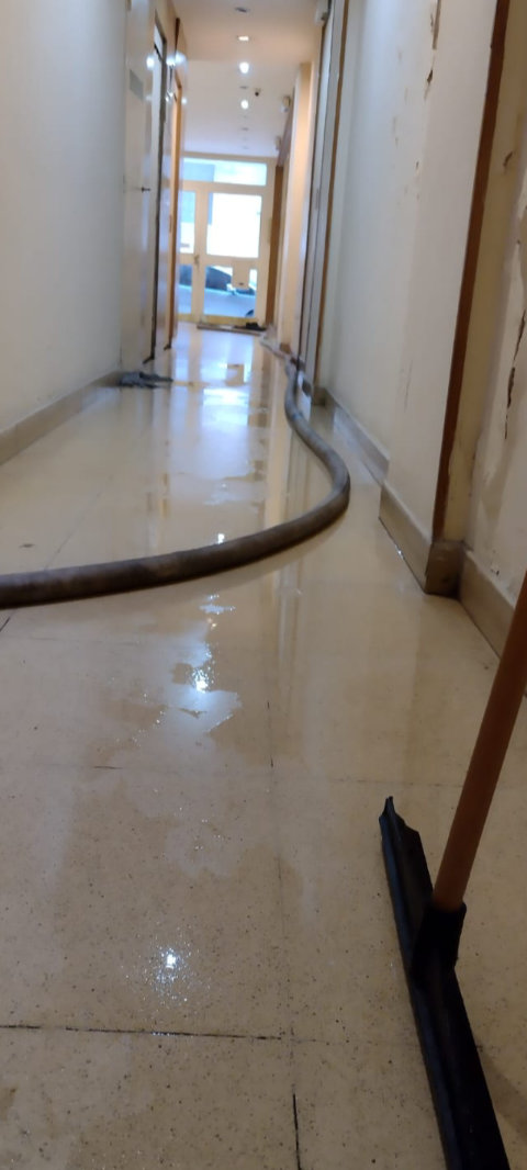 Manguera de la máquina destapadora tendida por el pasillo de un edificio